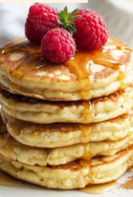 Stack of fluffy cottage cheese pancakes topped with fresh fruits and syrup