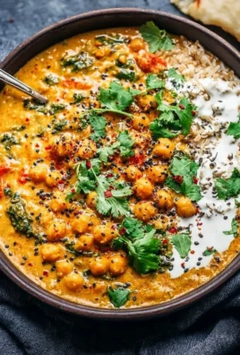Bowl of creamy coconut chickpea curry with vibrant vegetables and herbs