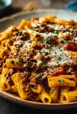 Creamy high protein beef pasta dish garnished with herbs.