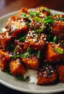 Delicious crispy honey garlic tofu served on a plate with garnish.