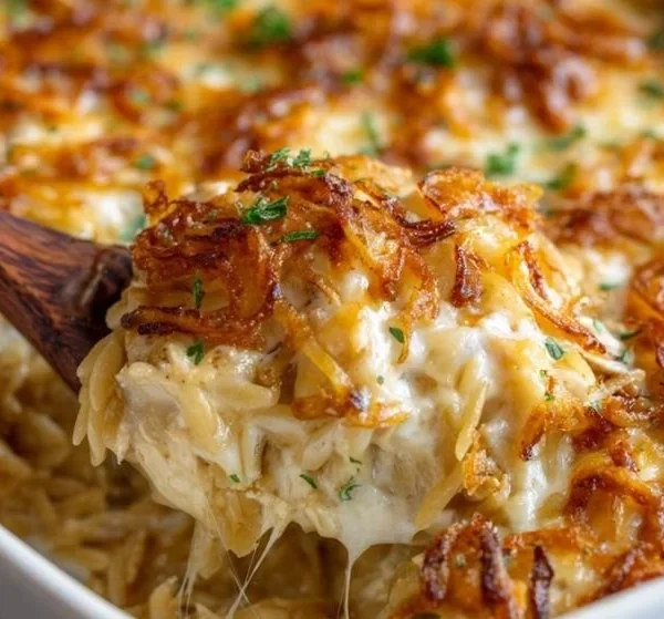 French onion chicken orzo casserole on a serving dish with cheese and herbs