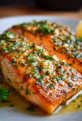 Delicious Garlic Butter Salmon served with herbs and lemon slices