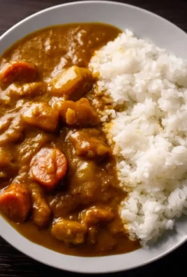 Delicious bowl of Japanese curry on rice topped with vegetables and meat