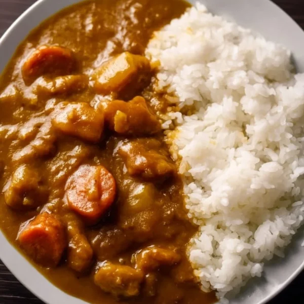 Delicious bowl of Japanese curry on rice topped with vegetables and meat