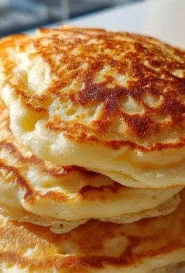 Fluffy high-protein Greek yogurt pancakes stacked on a plate with syrup