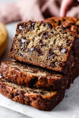Slice of chocolate chip banana bread on a wooden table
