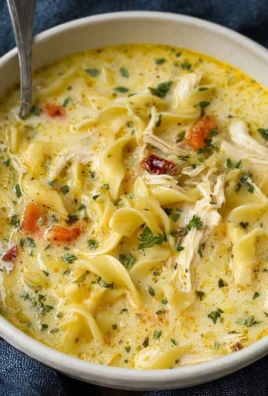 Bowl of creamy chicken noodle soup with herbs and vegetables