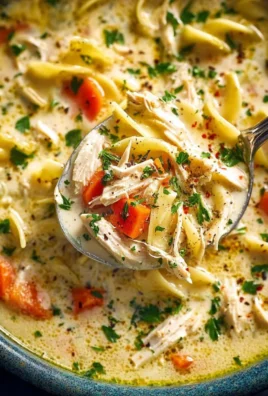 Bowl of creamy chicken noodle soup with tender chicken and vegetables