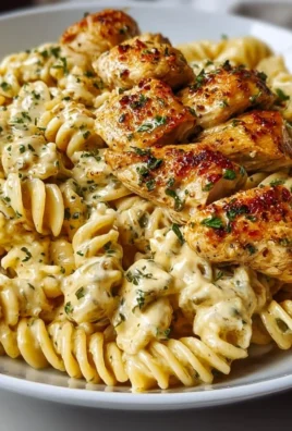 Creamy Garlic Parmesan Chicken Pasta served in a bowl with herbs and cheese
