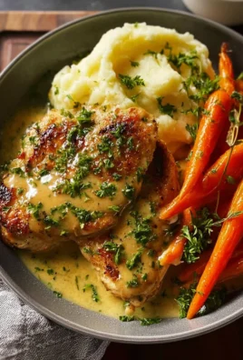 Creamy herb chicken with mashed potatoes and glazed carrots on a dinner plate