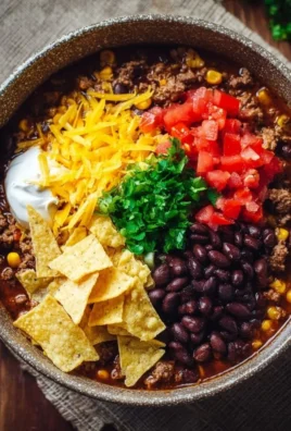 Delicious creamy taco soup garnished with cheese and avocado