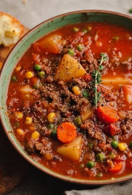 Bowl of delicious Hamburger Soup garnished with fresh herbs