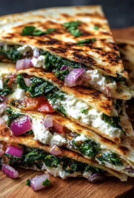 Mediterranean Quesadillas with spinach, feta, mozzarella, and red onion on a plate.