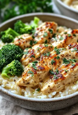 Creamy garlic chicken rice bowls garnished with herbs and served in a bowl.