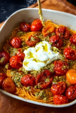 Creamy roasted tomato pesto spaghetti garnished with fresh basil and parmesan