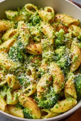 A bowl of easy healthy broccoli pasta topped with Parmesan cheese and fresh herbs.