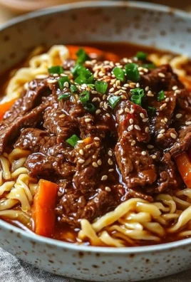 A bowl of Korean beef noodles topped with fresh herbs and vegetables