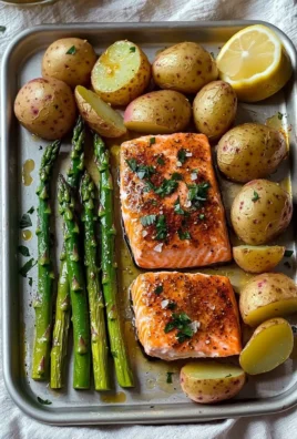 Salmon, potato, and asparagus sheet pan meal ready to serve on a kitchen table.