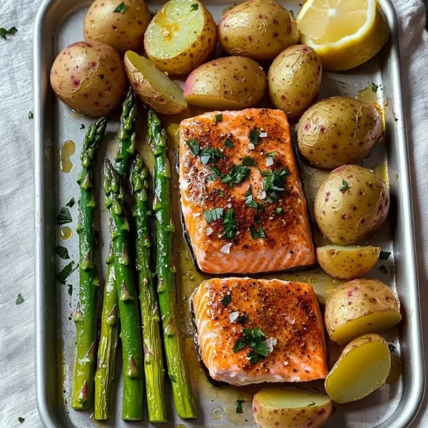Salmon, potato, and asparagus sheet pan meal ready to serve on a kitchen table.