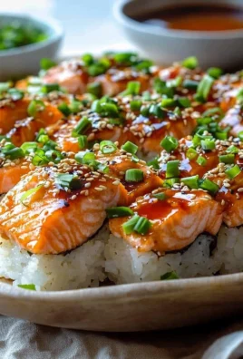 Delicious Spicy Salmon Sushi Bake topped with creamy sauce and garnished.